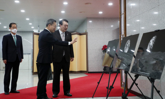 윤석열 대통령이 3일 서울 용산 대통령실 청사에서 열린 국무회의에 앞서 이종호 과학기술정보통신부 장관과 함께 다누리호가 찍은 달과 지구 사진을 관람하고 있다. 대통령실통신사진기자단=연합뉴스